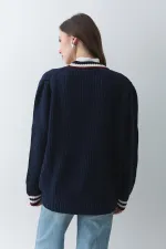 Gilet cardigan bleu marine et bordeaux pour femme, avec poches, col et manches de couleur.