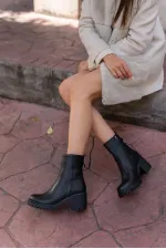 Bottes noires à semelles épaisses arrivant à la cheville