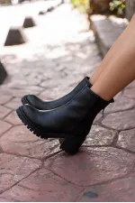 Bottes noires à semelles épaisses arrivant à la cheville