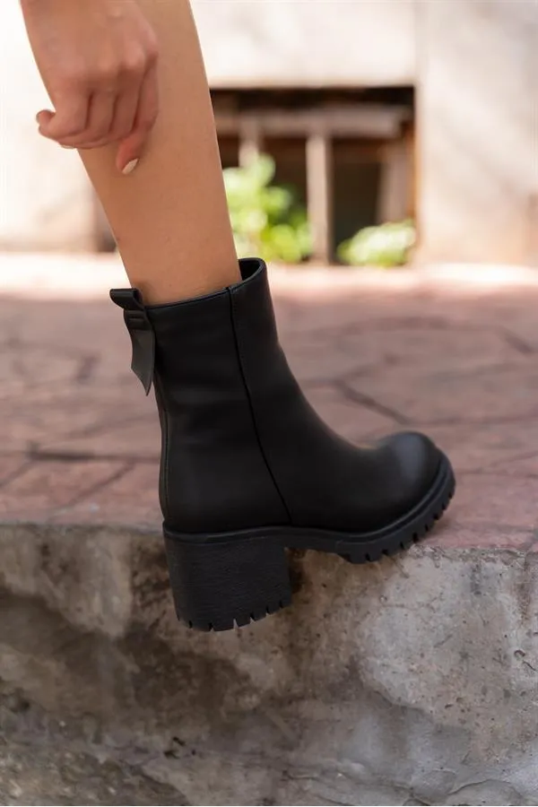 Bottes noires à semelles épaisses arrivant à la cheville