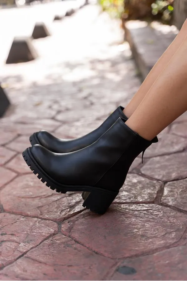 Bottes noires à semelles épaisses arrivant à la cheville
