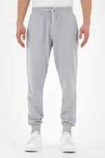 Pantalon de survêtement gris pour homme, coupe classique, avec étiquette, poches arrière et latérales.