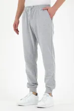 Pantalon de survêtement gris pour homme, coupe classique, avec étiquette, poches arrière et latérales.