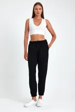 Pantalon de jogging confortable en coton épais noir pour femme, avec ourlet élastiqué et poches.