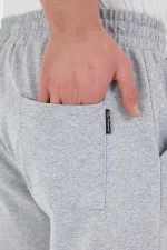 Pantalon de survêtement gris pour homme, coupe classique, avec étiquette, poches arrière et latérales.