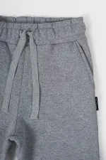 Pantalon de survêtement gris en coton épais avec taille et chevilles élastiques, pour filles de 5 à 12 ans.