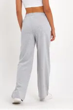Pantalon de survêtement 4 pièces pour femme, coupe ample, poches latérales, coloris noir, bleu marine, anthracite et gris.