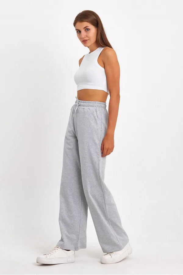 Pantalon de survêtement 4 pièces pour femme, coupe ample, poches latérales, coloris noir, bleu marine, anthracite et gris.