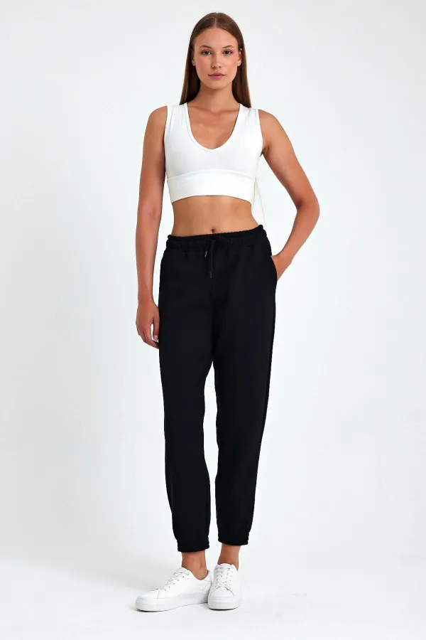 Pantalon de jogging confortable en coton épais noir pour femme, avec ourlet élastiqué et poches.