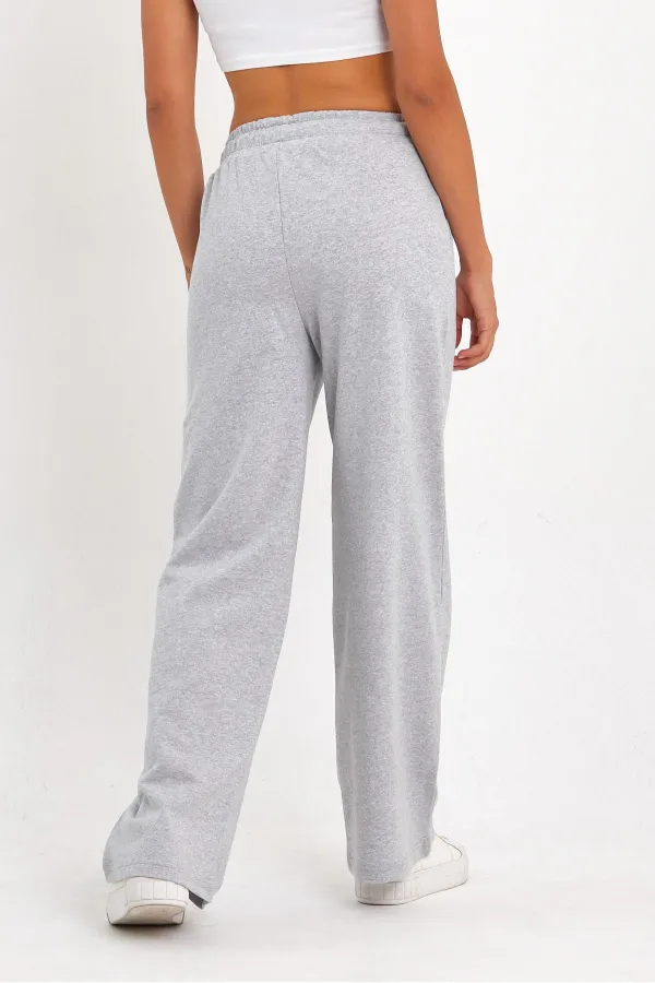 Pantalon de survêtement 4 pièces pour femme, coupe ample, poches latérales, coloris noir, bleu marine, anthracite et gris.