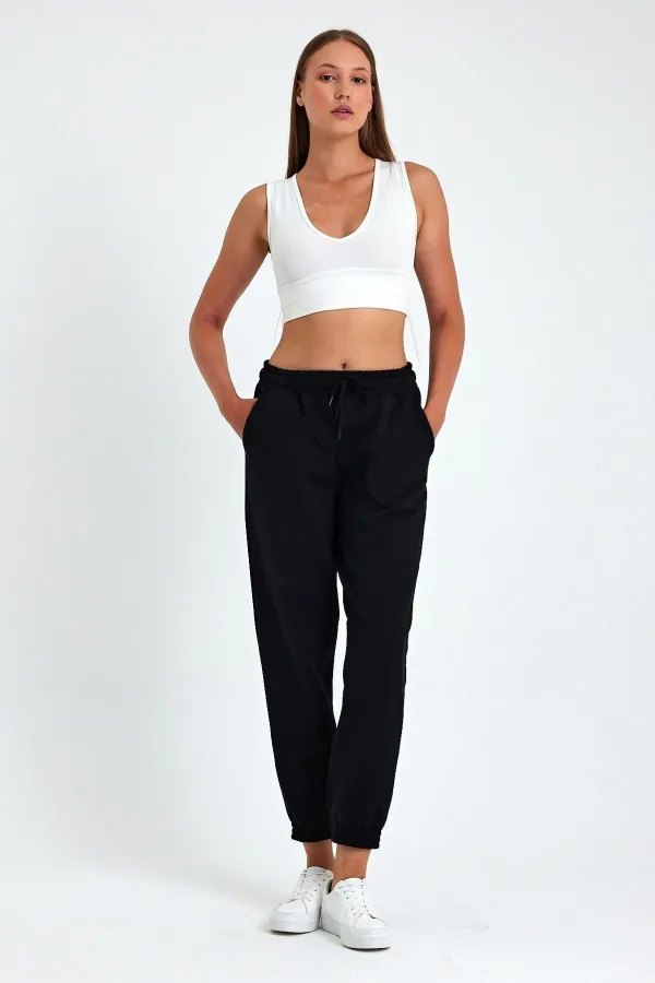 Pantalon de jogging confortable en coton épais noir pour femme, avec ourlet élastiqué et poches.