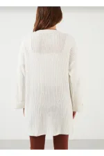 Gilet en maille ample pour femme, avec manches repliées et poches.