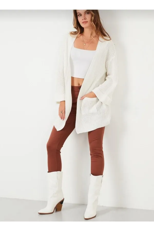 Gilet en maille ample pour femme, avec manches repliées et poches.