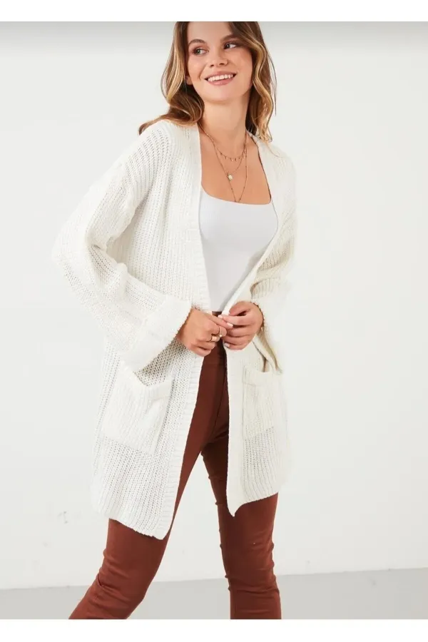 Gilet en maille ample pour femme, avec manches repliées et poches.