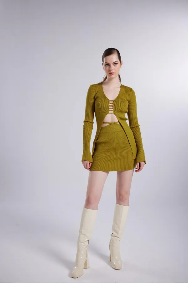 Mini-jupe en feutrine verte avec ceinture apparente.