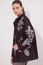 VESTE EN JEAN AVEC BRODERIE APPLIQUE ET CEINTURE.