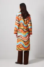 ABSTRACT PATTERNED TRENCH COAT WITH GATHERED WAIST.