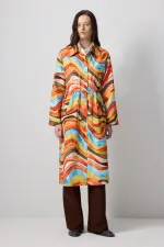 ABSTRACT PATTERNED TRENCH COAT WITH GATHERED WAIST.