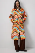 ABSTRACT PATTERNED TRENCH COAT WITH GATHERED WAIST.