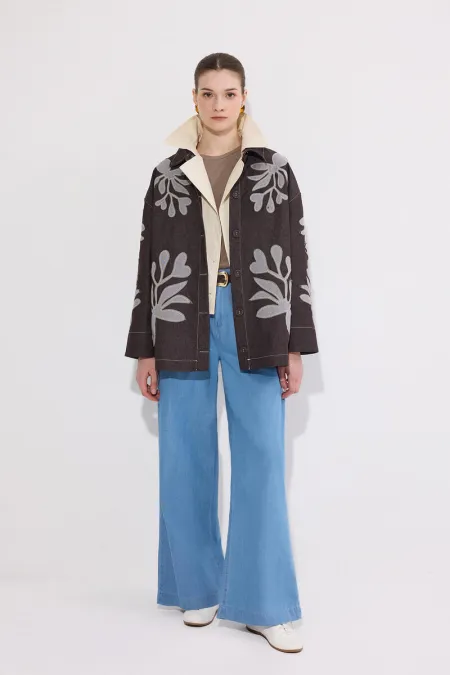 VESTE EN JEAN AVEC BRODERIE APPLIQUE ET CEINTURE.