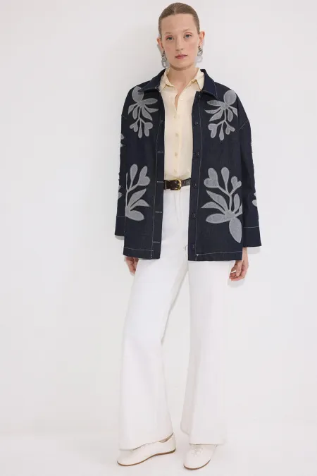 VESTE EN JEAN AVEC BRODERIE APPLIQUE ET CEINTURE.