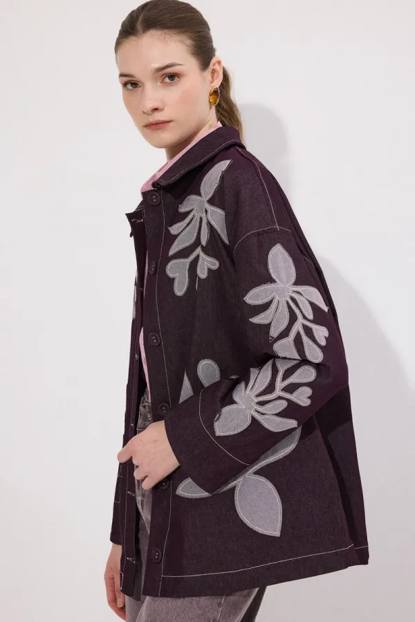 VESTE EN JEAN AVEC BRODERIE APPLIQUE ET CEINTURE.