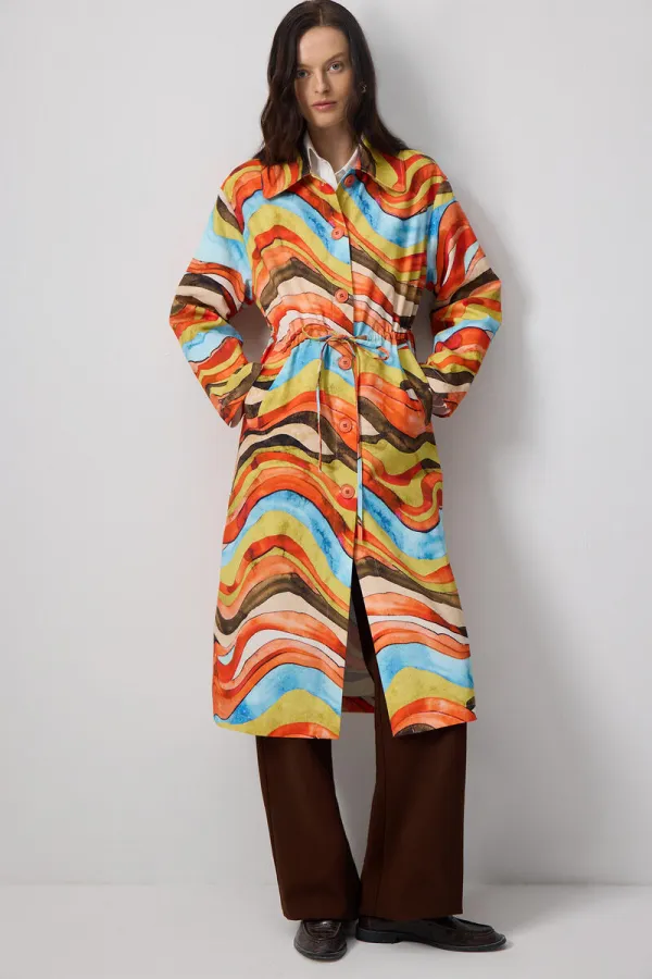 ABSTRACT PATTERNED TRENCH COAT WITH GATHERED WAIST.