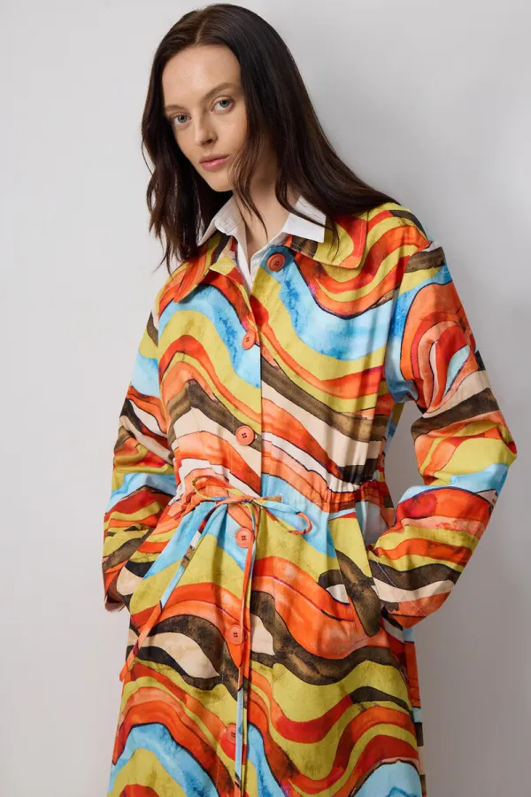 ABSTRACT PATTERNED TRENCH COAT WITH GATHERED WAIST.