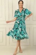 Wrap-neck, slit, ruffled sleeve, patterned, belted, pleated, lined satin dress.