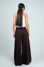 Pantalon Osyho pour femme, jambes larges, taille élastique, poches et plis sur le devant.