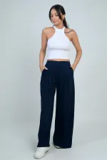 Pantalon Osyho pour femme, jambes larges, taille élastique, poches et plis sur le devant.