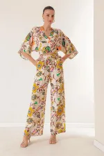 Ensemble deux pièces : pantalon palazzo à taille élastique, poches, col en V devant et dos, crop top à motif floral.