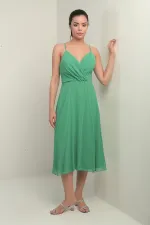 Robe en mousseline évasée à bretelles croisées et dos lacé, doublée, avec encolure cache-cœur et bretelles.