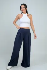 Pantalon Osyho pour femme, jambes larges, taille élastique, poches et plis sur le devant.