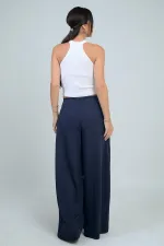 Pantalon Osyho pour femme, jambes larges, taille élastique, poches et plis sur le devant.