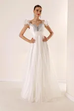 Robe longue en tulle doublée, décolleté en V devant et dos, bretelles spaghetti, manches tombantes, détail en pierre sur le devant.