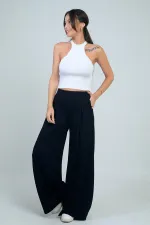 Pantalon Osyho pour femme, jambes larges, taille élastique, poches et plis sur le devant.