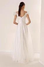 Robe longue en tulle doublée, décolleté en V devant et dos, bretelles spaghetti, manches tombantes, détail en pierre sur le devant.