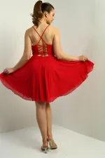 Robe courte évasée en mousseline doublée, à bretelles, à nouer dans le dos et à ouverture sur le devant