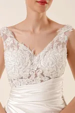 Robe longue en satin ornée de dentelle perlée, drapée de façon transparente et doublée.