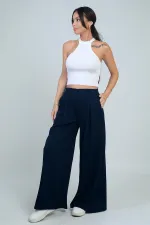 Pantalon Osyho pour femme, jambes larges, taille élastique, poches et plis sur le devant.