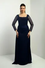 Robe de soirée longue en crêpe satin, doublée, à col carré et manches perlées, coupe ample.