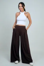 Pantalon Osyho pour femme, jambes larges, taille élastique, poches et plis sur le devant.