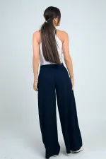 Pantalon Osyho pour femme, jambes larges, taille élastique, poches et plis sur le devant.
