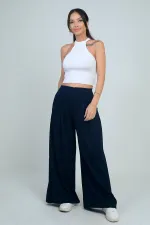 Pantalon Osyho pour femme, jambes larges, taille élastique, poches et plis sur le devant.