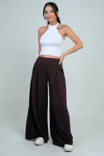 Pantalon Osyho pour femme, jambes larges, taille élastique, poches et plis sur le devant.