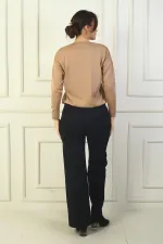 Pantalon en acier à jambes larges pour femme, avec taille élastique, poches latérales et finitions.