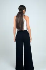 Pantalon Osyho pour femme, jambes larges, taille élastique, poches et plis sur le devant.