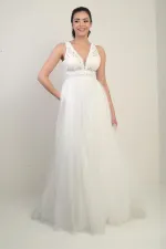 Robe de princesse longue doublée, à col en V et bretelles épaisses, ornée de dentelle et de tulle.