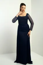 Robe de soirée longue en crêpe satin, doublée, à col carré et manches perlées, coupe ample.